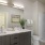 Model bathroom at our senior living apartments in Farmington, featuring white countertops and brown cabinetry.
