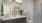 Model bathroom at our senior living apartments in Farmington, featuring white countertops and brown cabinetry.