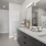 Model bathroom at our senior living apartments in Farmington, featuring white countertops and wood grain floor paneling.